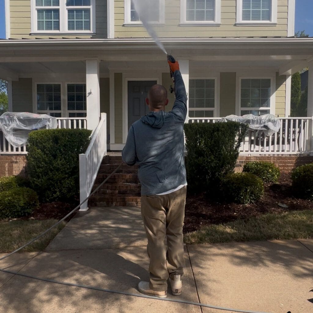 technician soft washing a home