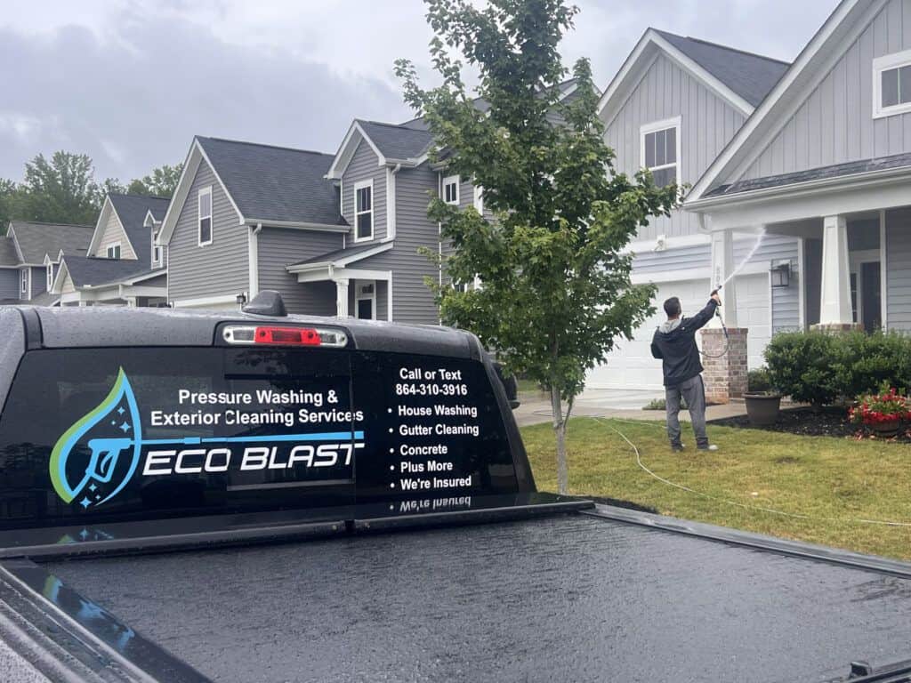 technician soft washing a home exterior